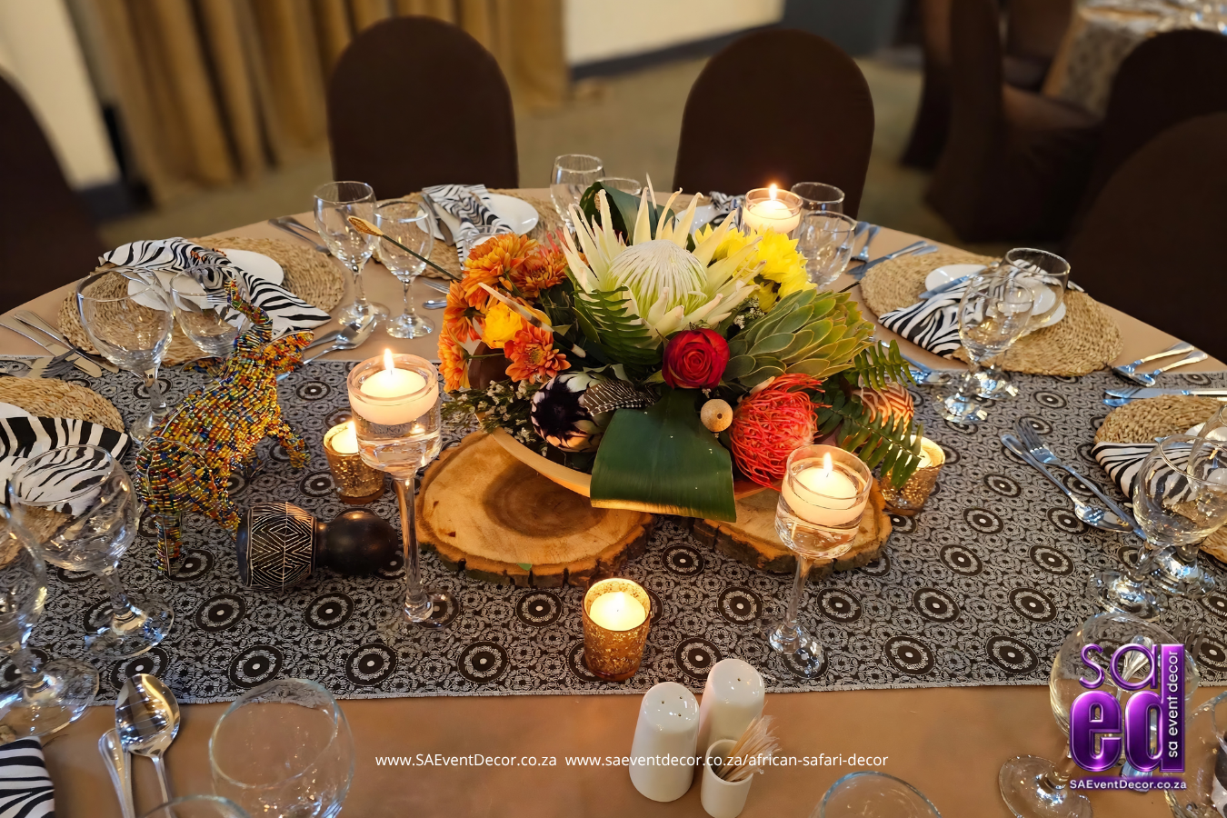 intricate african floral arrangement on wooden slats paired with african print cloths and candles designed by SA Event Decor 1