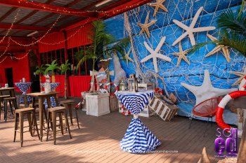 Outdoor cocktail area in nautical themed high top tables and starfish printed backdrop designed by SA Event Decor